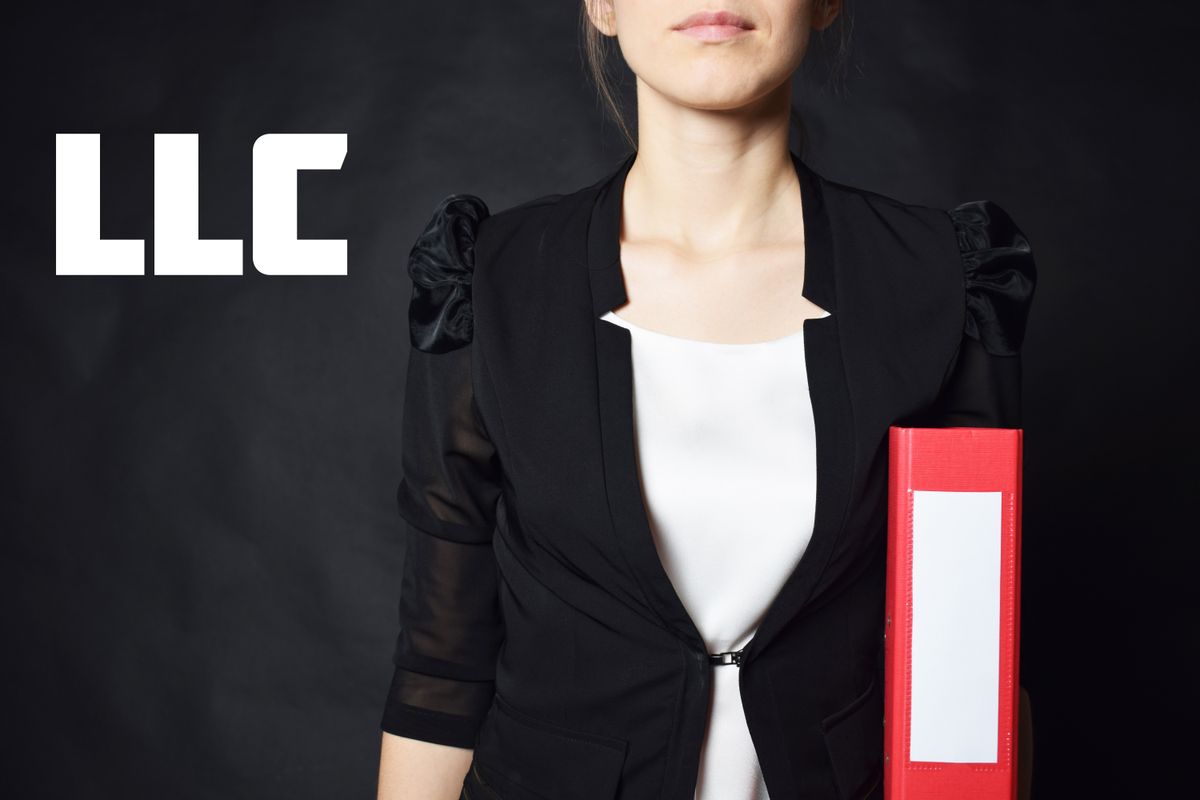 A businesswoman holds a folder with the inscription LLC
