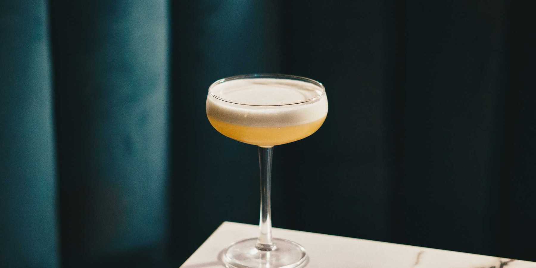 A cocktail sitting on a marble bar counter