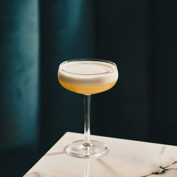 A cocktail sitting on a marble bar counter