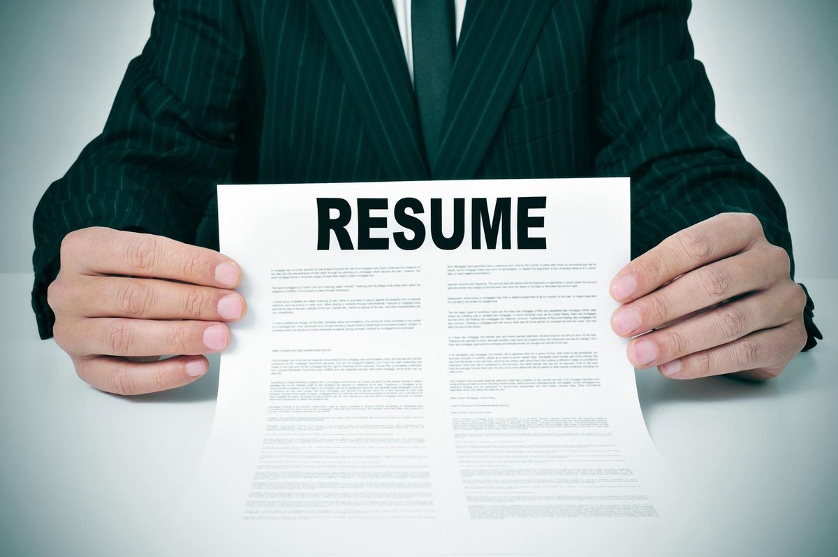 a man wearing a suit showing his resume