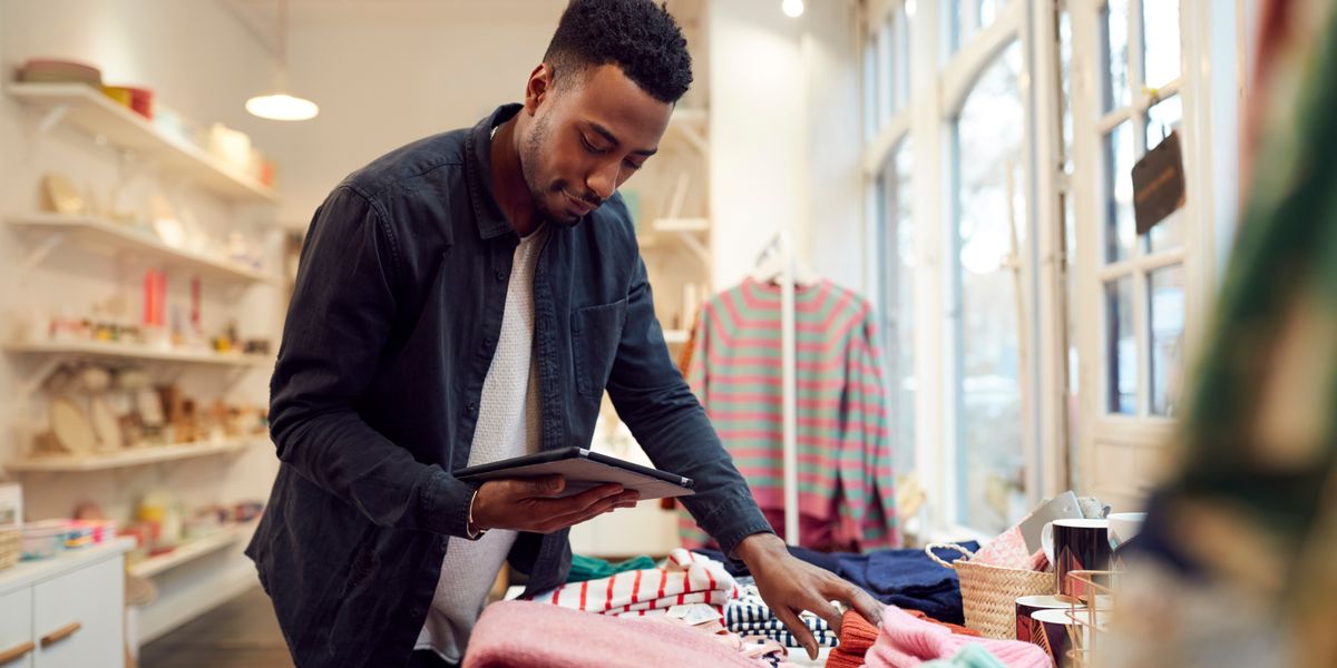 A small business owner checks his retail stock
