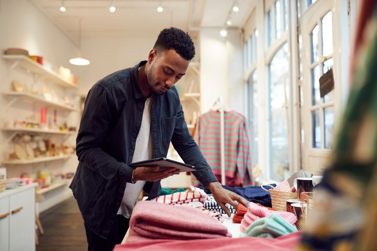 A small business owner checks his retail stock