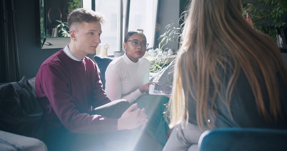A team of employees listening to their leader and one another