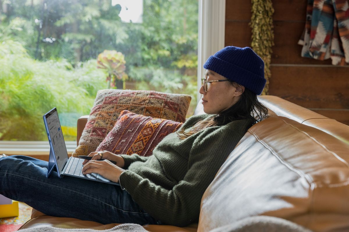 An entrepreneur working on her side hustle on the couch