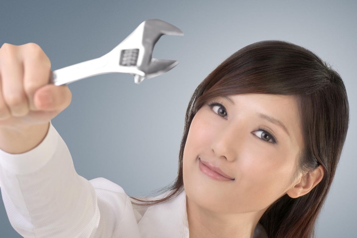 Business woman fix by using wrench
