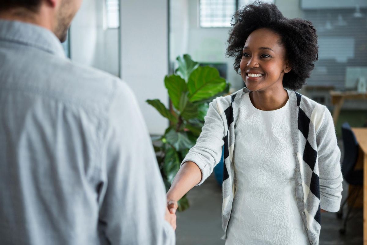Business woman shaking hands with colleague