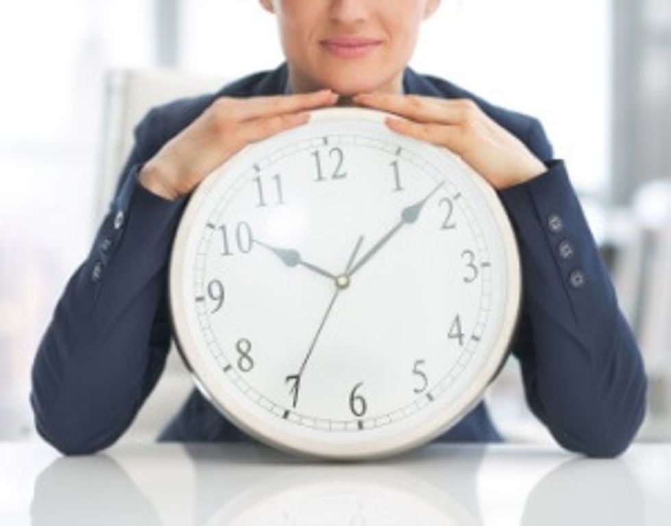 business woman with clock trying to beat procrastination