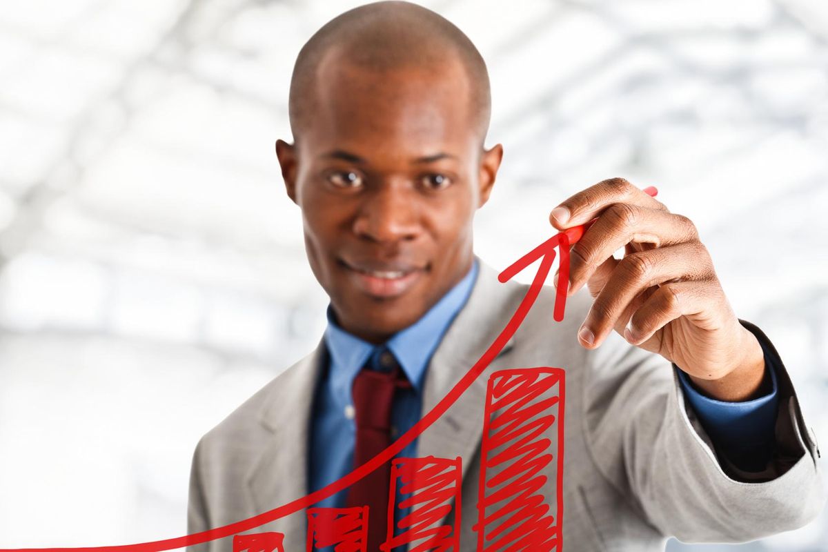 Businessman drawing a positive graph