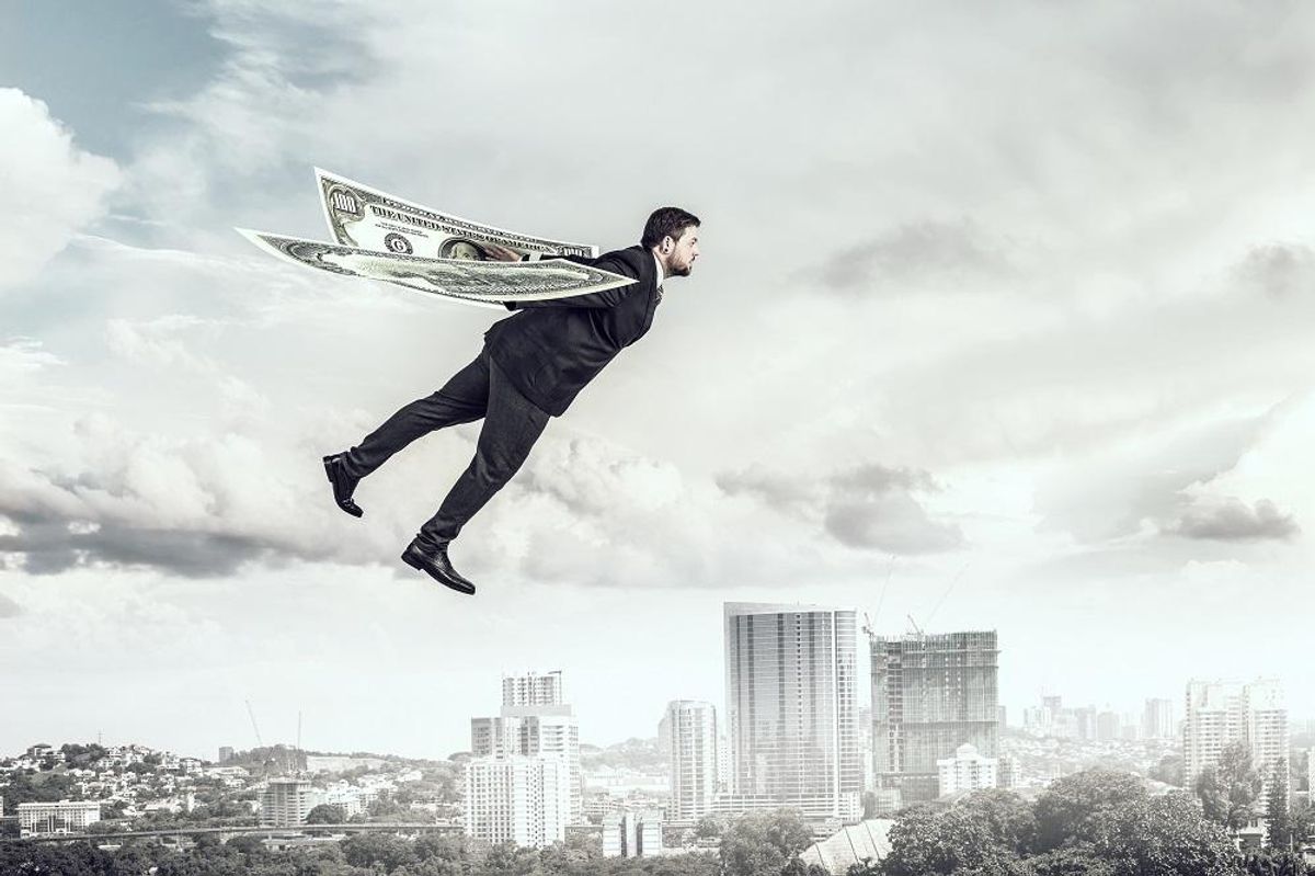Businessman flying in sky with dollar bills wings