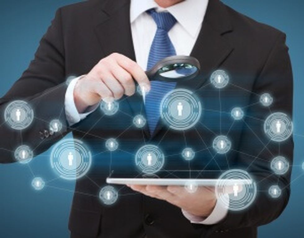 businessman hand holding magnifier over tablet