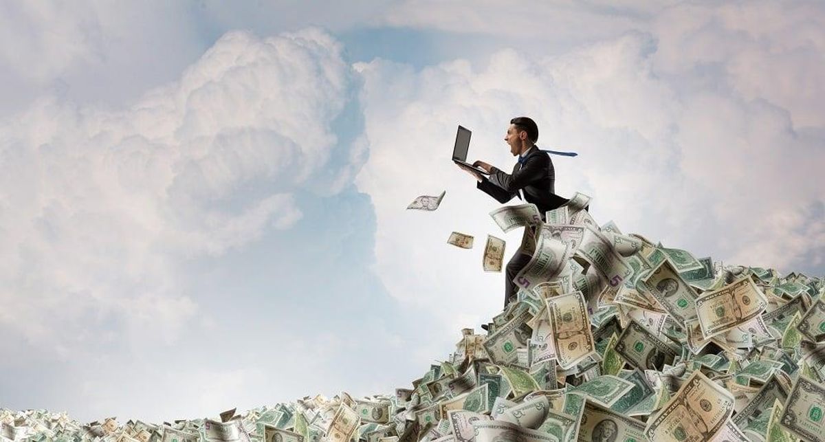 businessman in pile of money banknotes