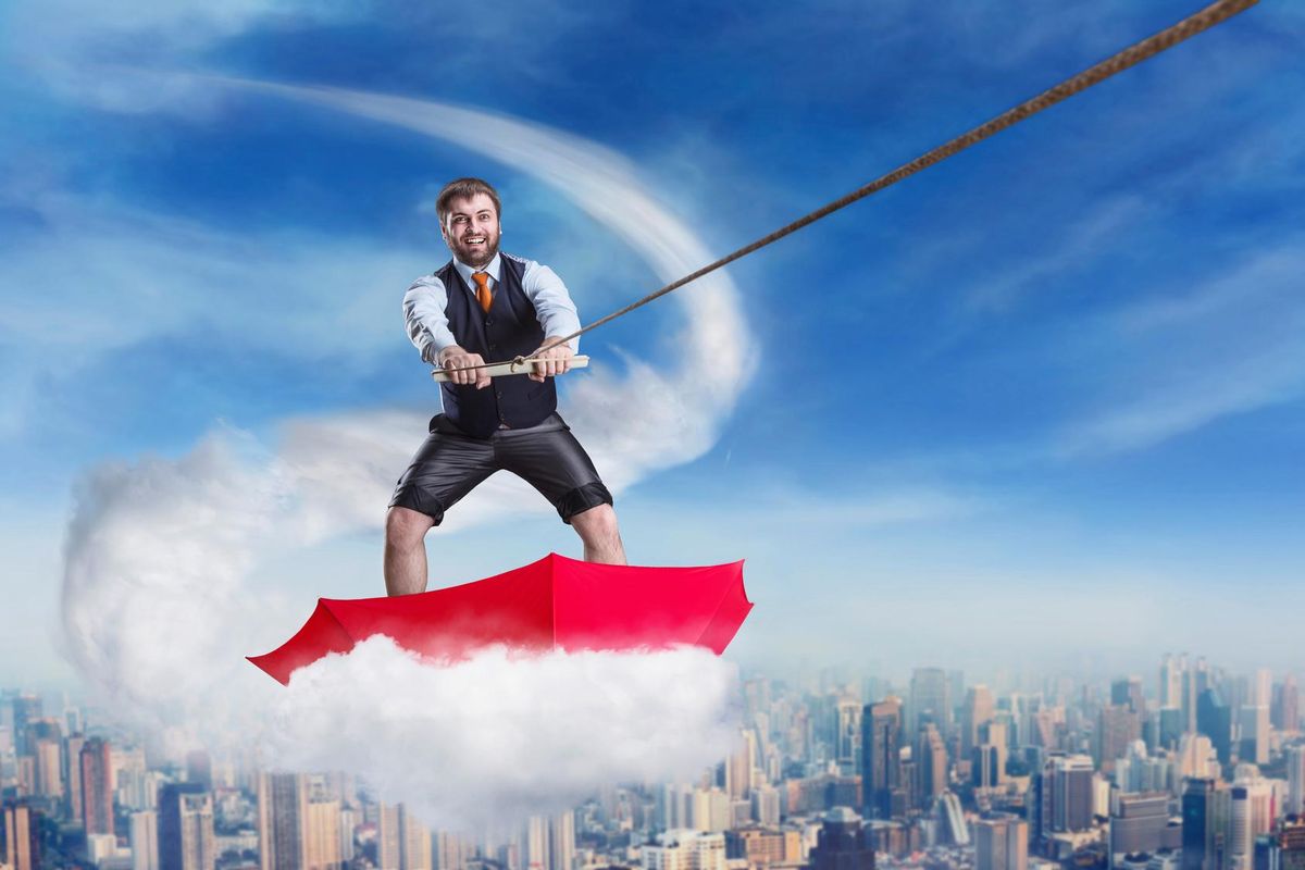 Businessman in umbrella on the cloud