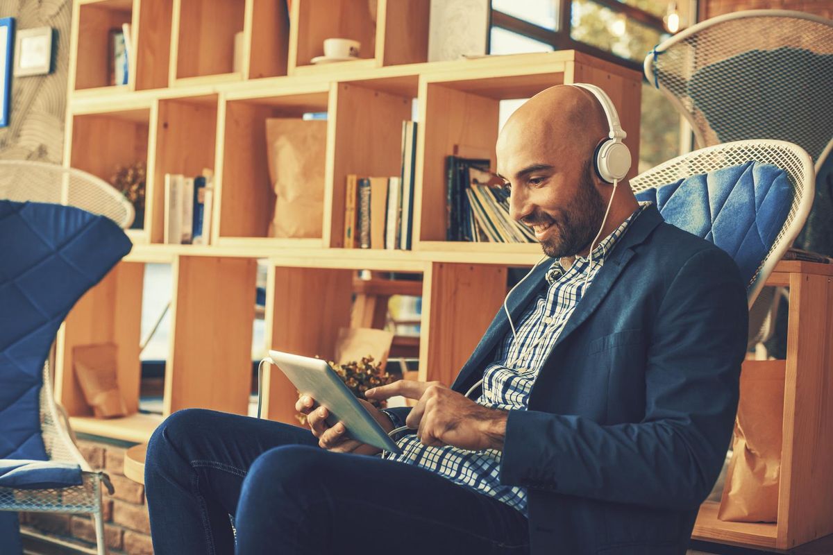 Businessman listening to music via digital tablet