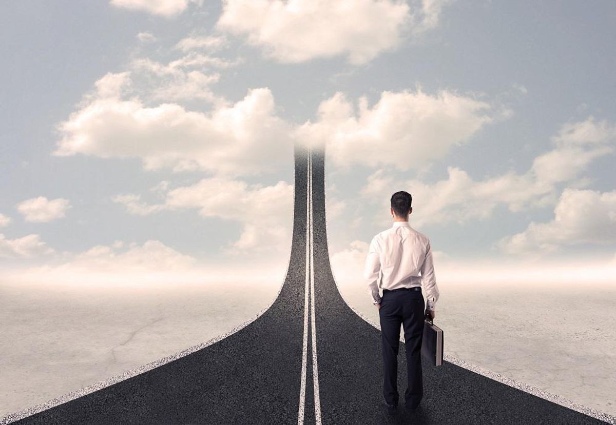 Businessman looking at 3d road that goes up in the sky