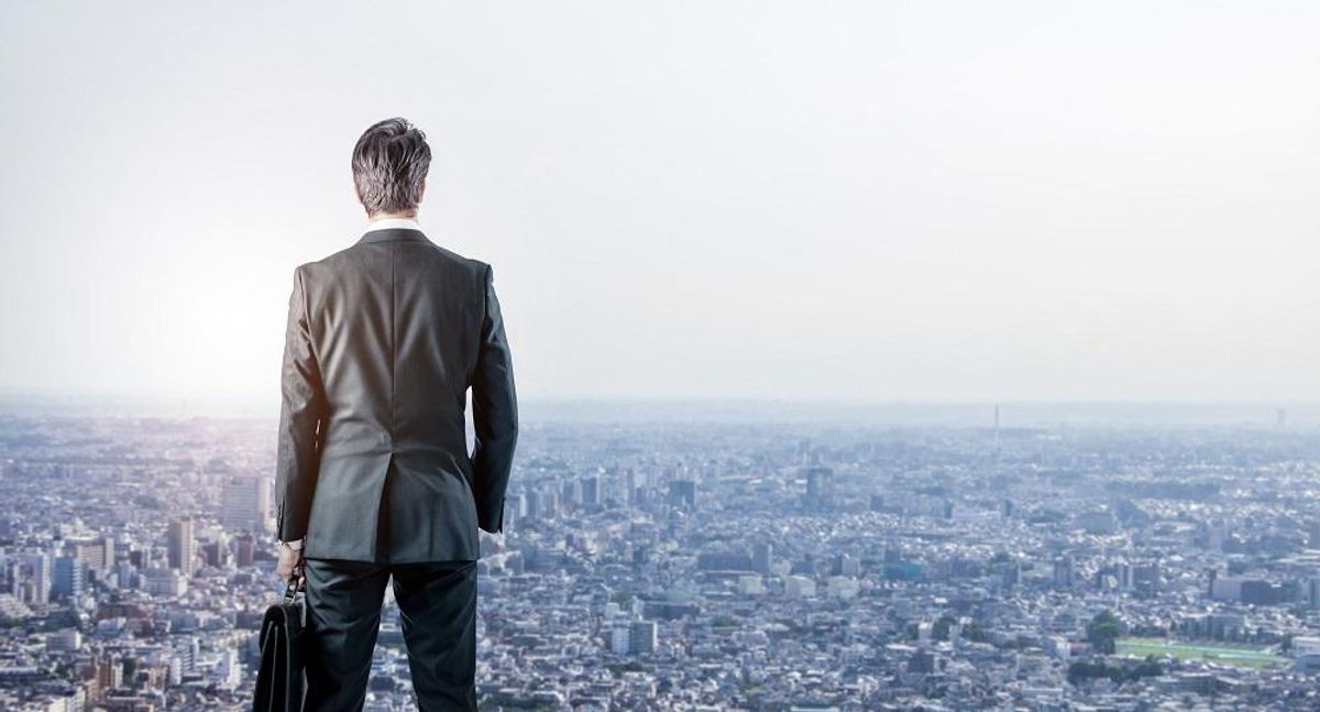 businessman looking down a modern city