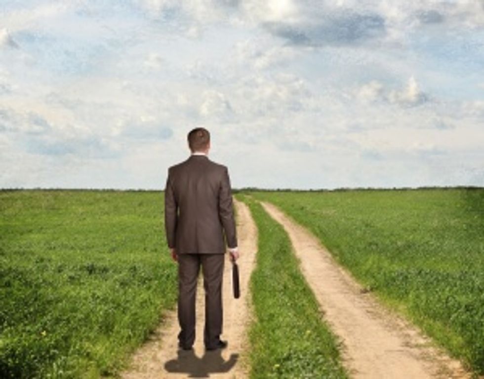 Businessman standing on dirt path