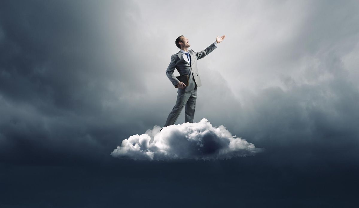 businessman with book in hand standing on cloud