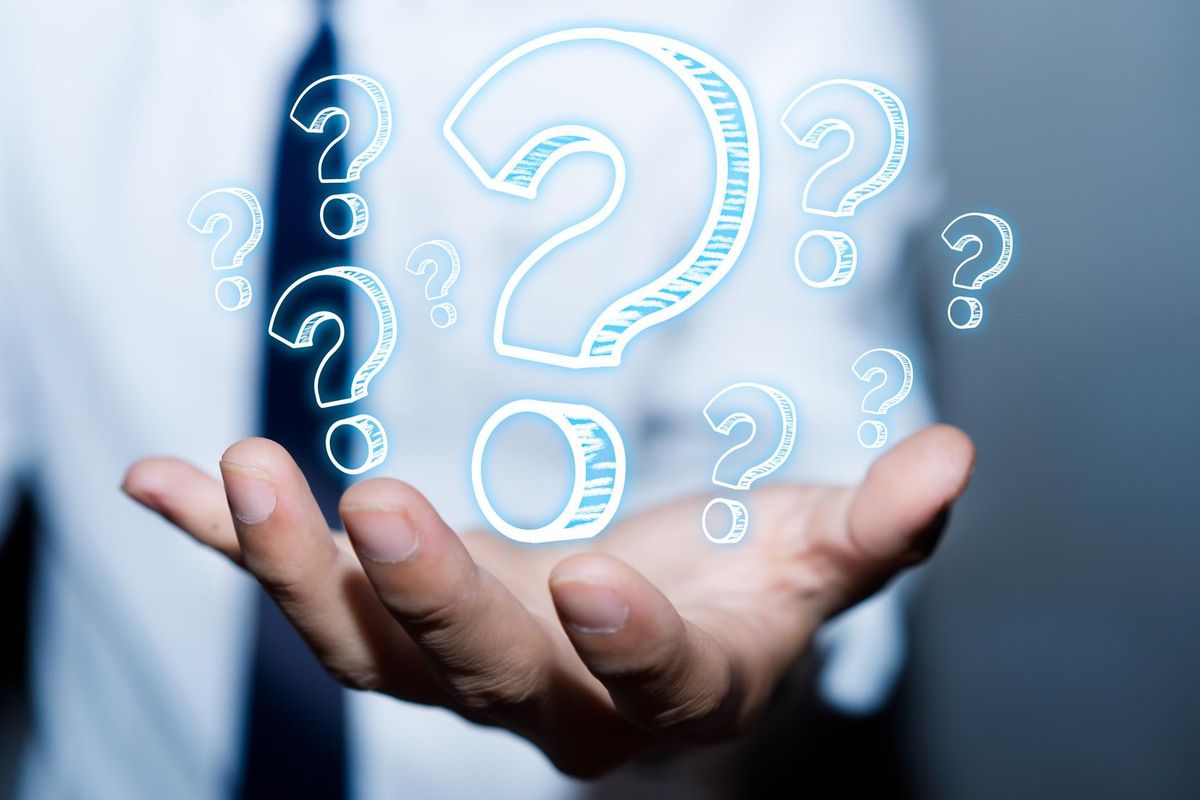 Businessman with question marks in his hand