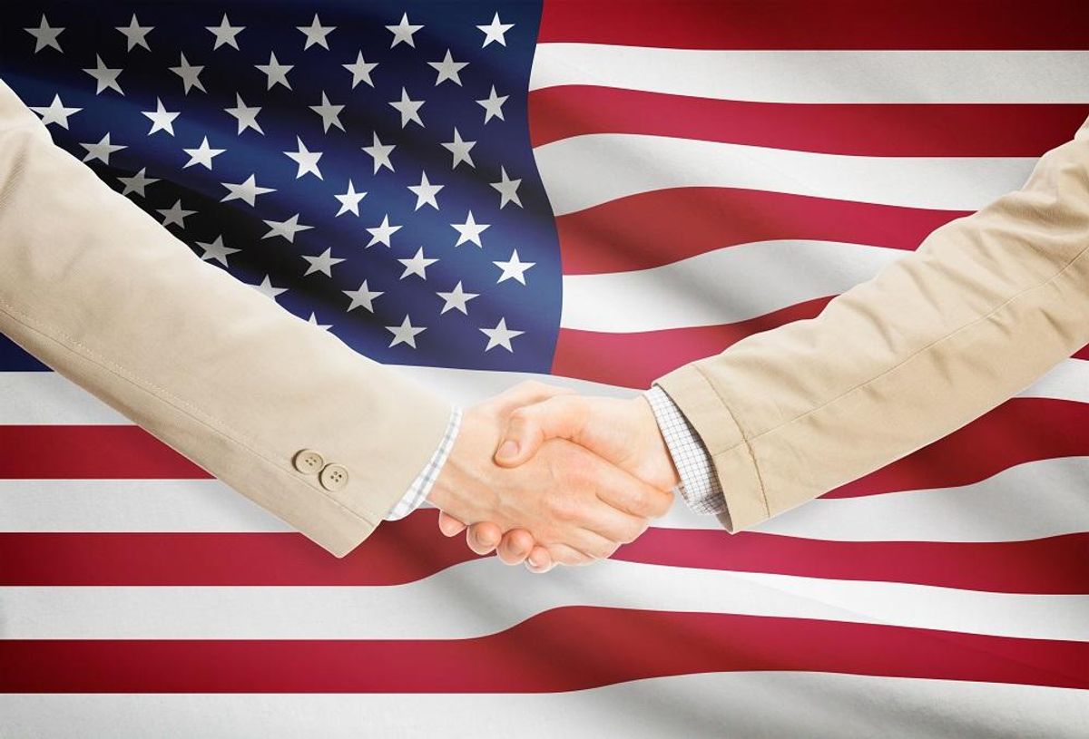 Businessmen handshake with United States flag on background