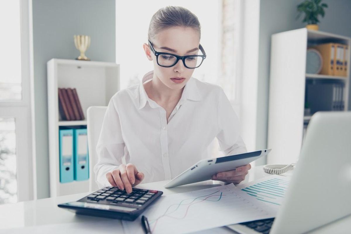 Businesswoman calculating costs