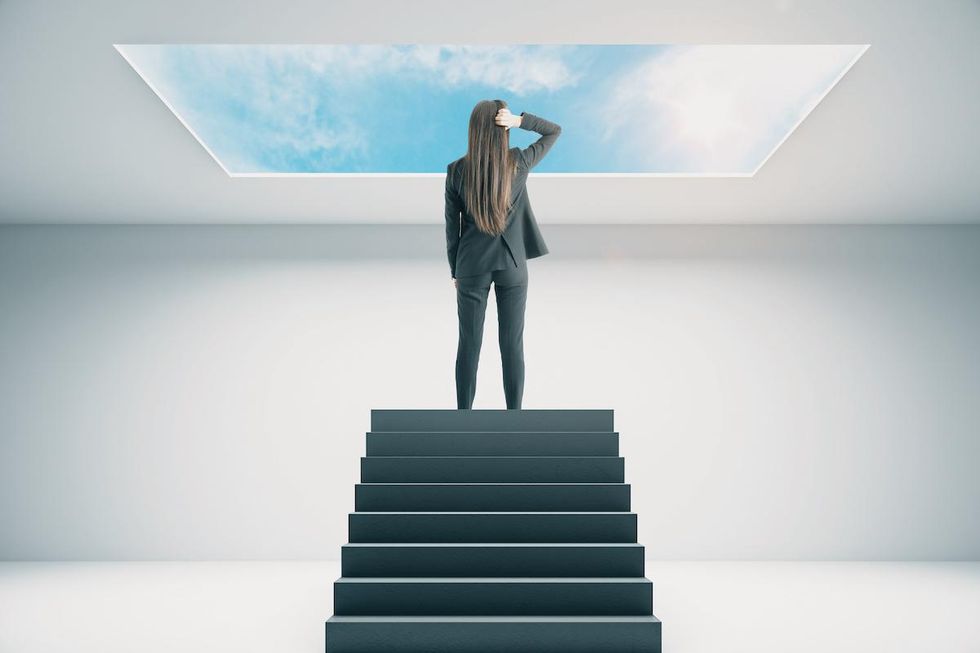 businesswoman looking through glass ceiling
