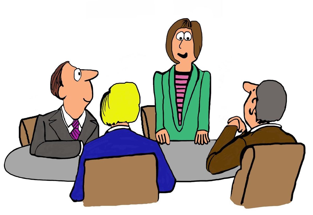 businesswoman standing and speaking in a meeting.