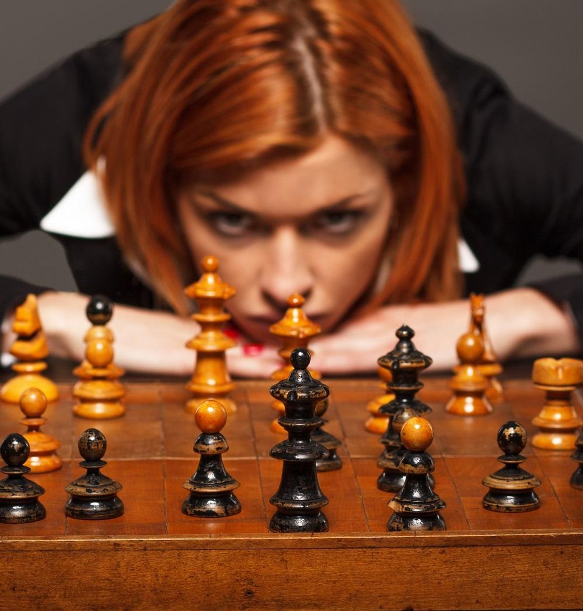 Businesswoman thinking about her next move in a game of chess