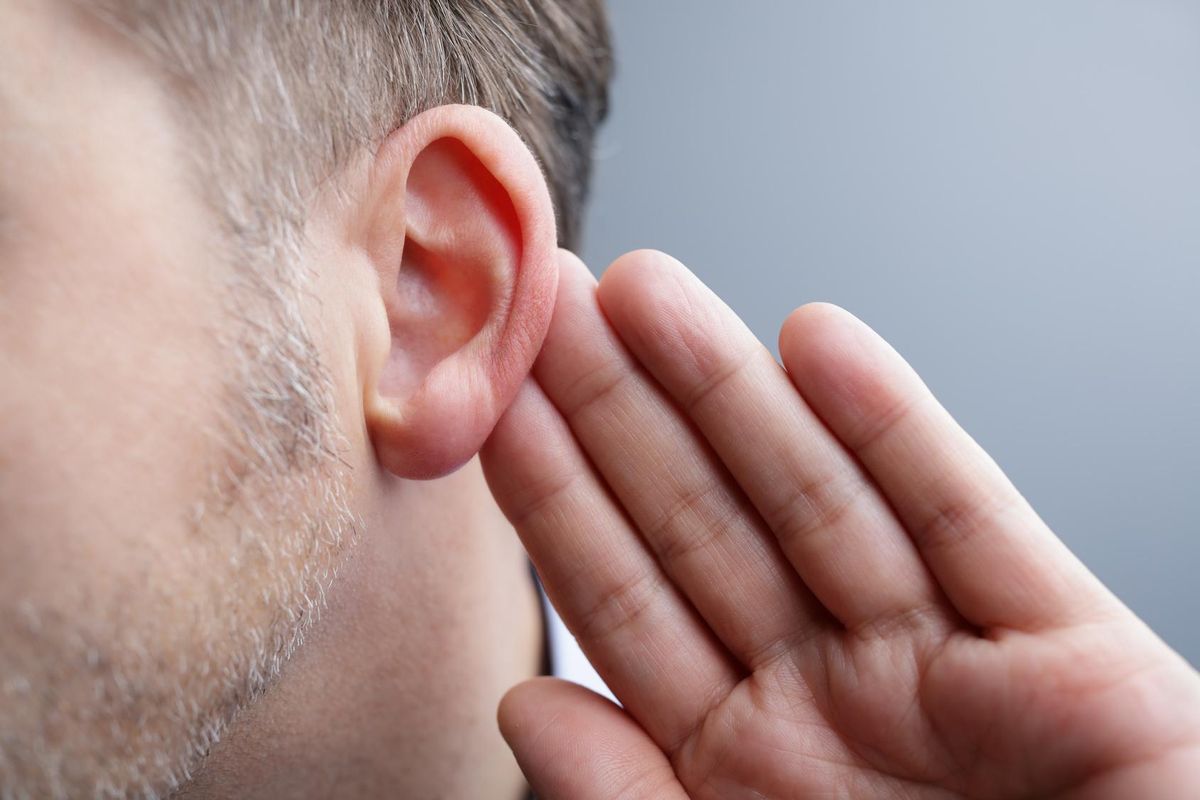 Close-up of man with hand on ear listening