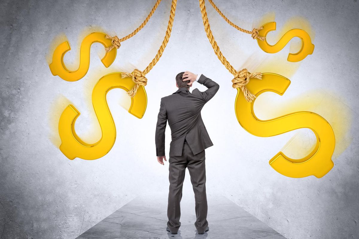 Confused businessman looking on dollar signs