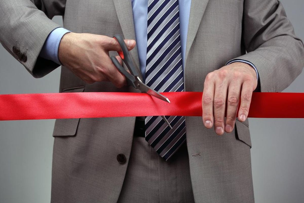 Cutting a red ribbon with scissors