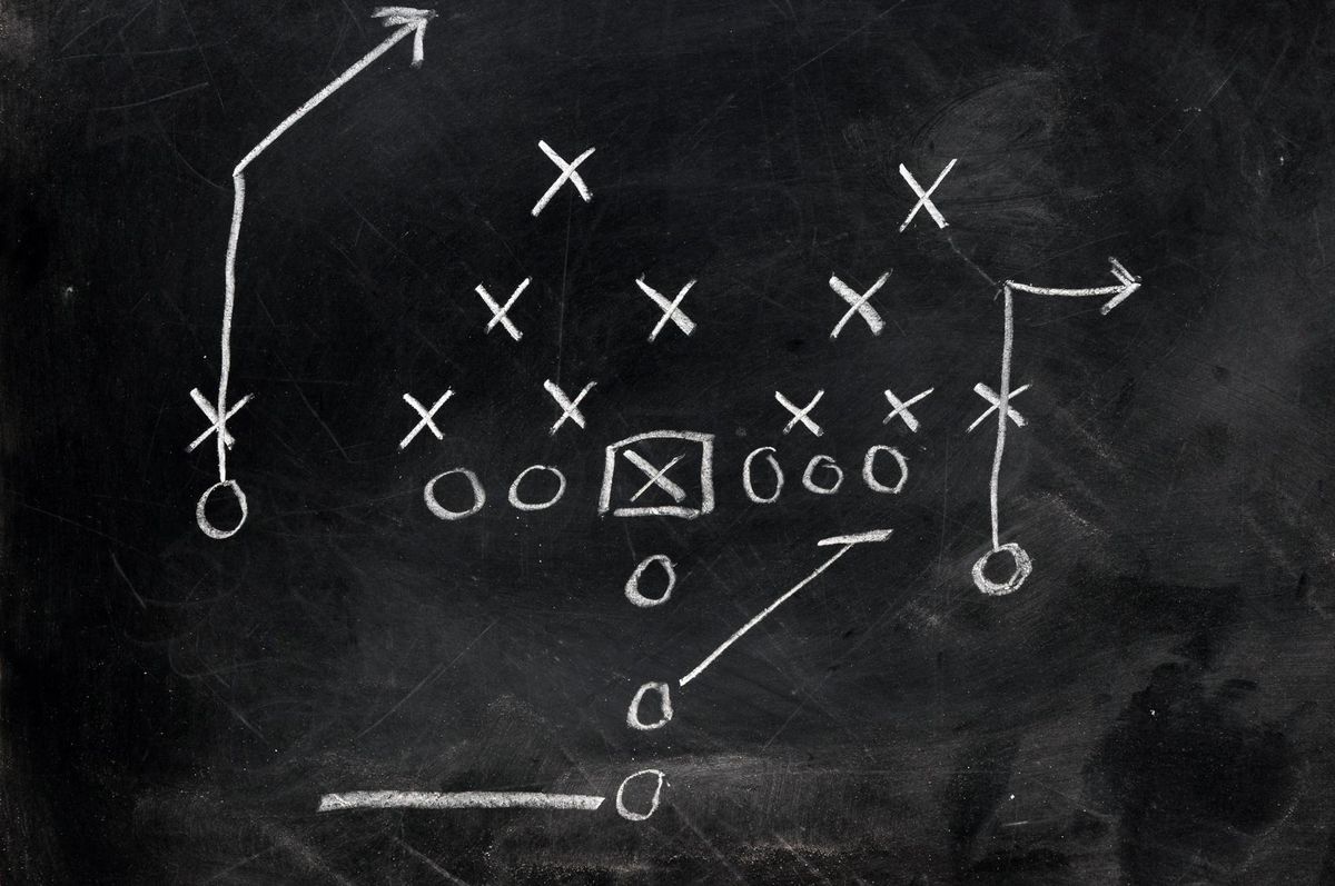 Diagram of football play on black chalkboard.Diagram of football play on black chalkboard.