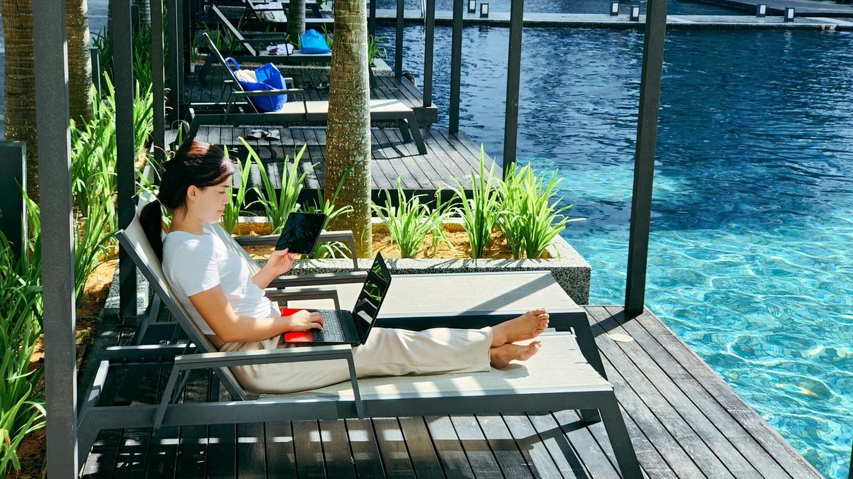 Entrepreneur working on her location independent business by the ocean