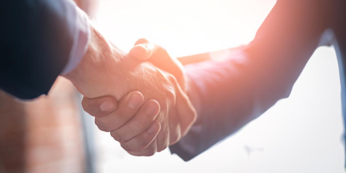 Fellow franchise owners shaking hands.