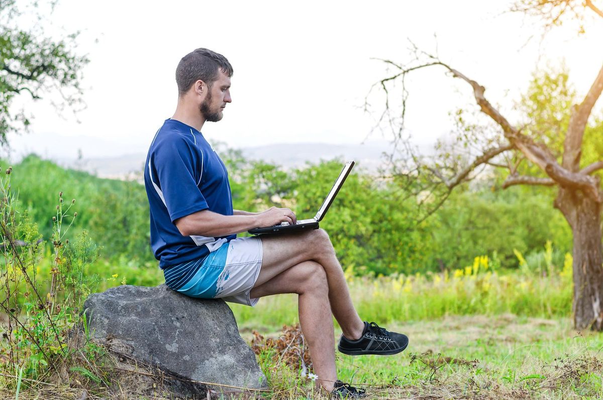freelancer with laptop outdoors