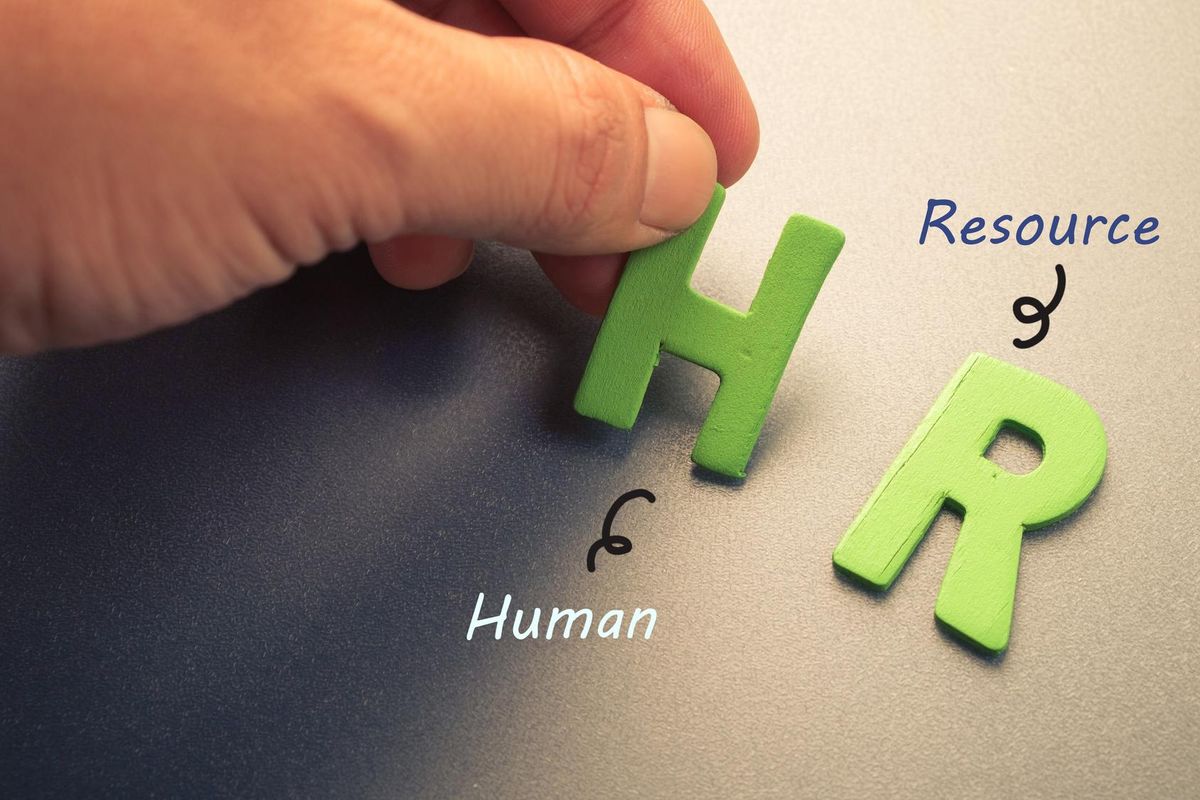 Hand arrange wood letters as HR (Human Resource)