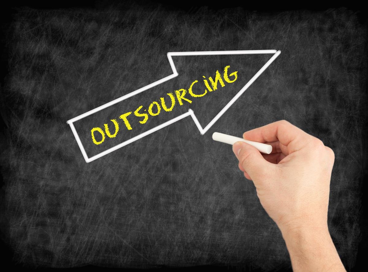 Hand writing text on chalkboard about how to outsource work