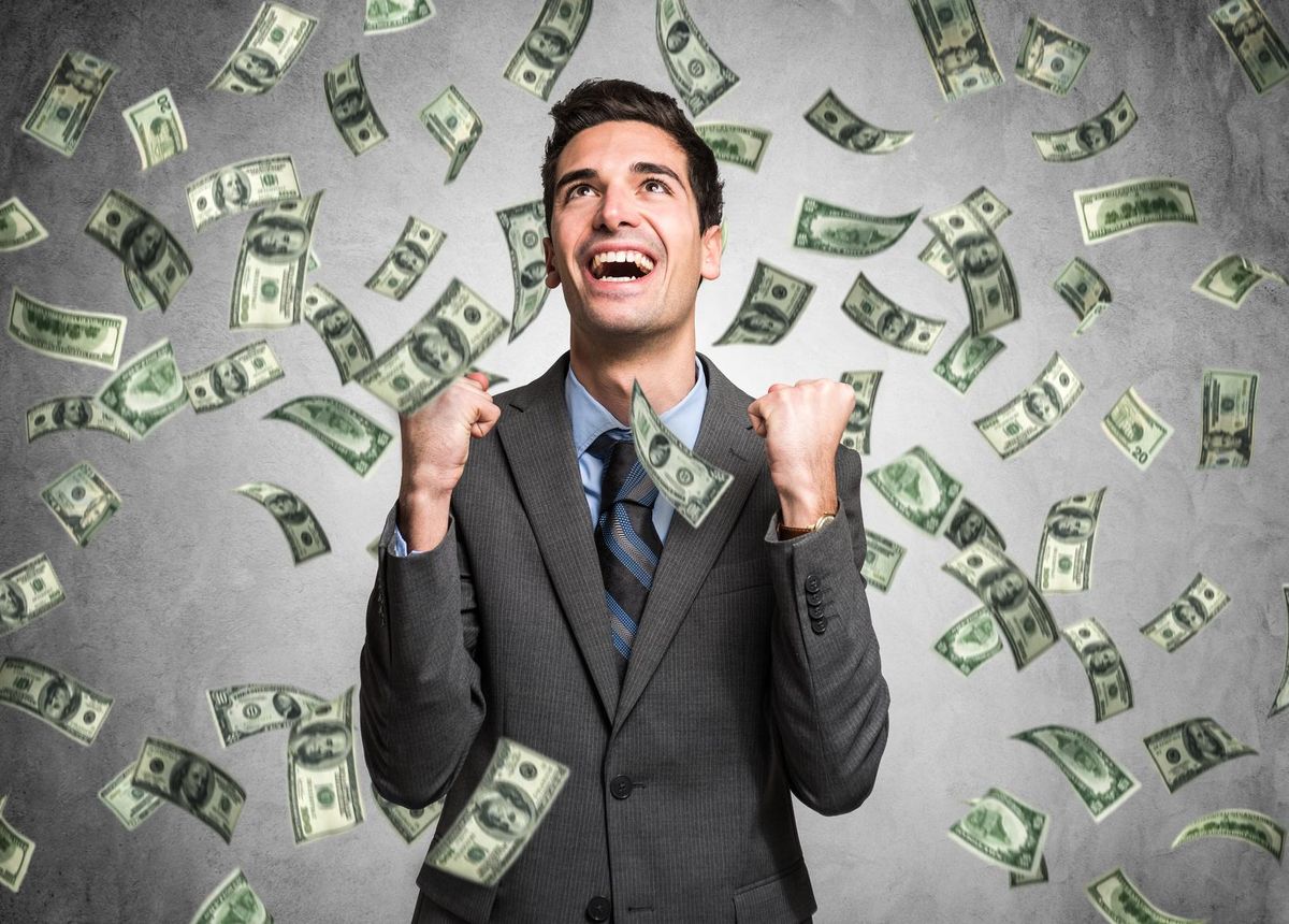 Happy man enjoying the rain of money