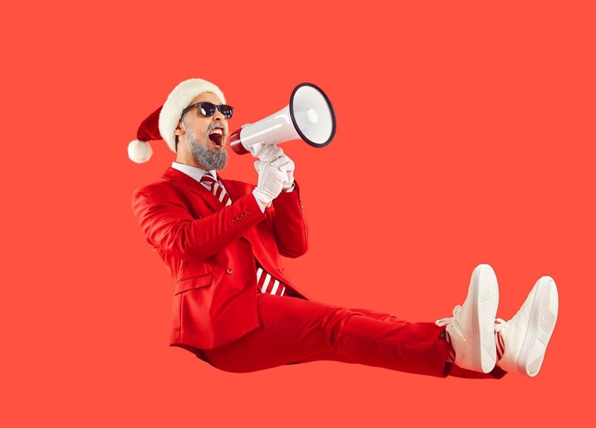 Happy man in Santa hat doing holiday marketing