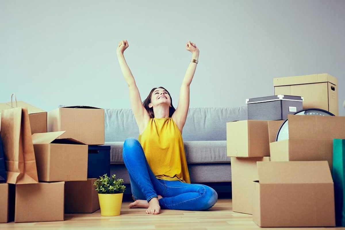 Happy young woman moving to new home