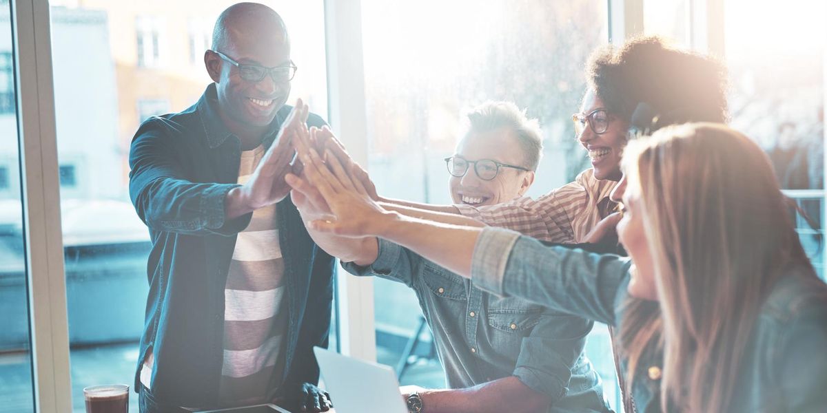 High fiving coworkers at a company offsite