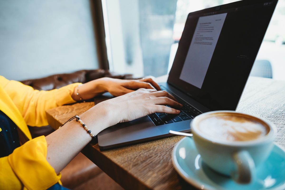 Independent contractor works on a project on her laptop at a cafe