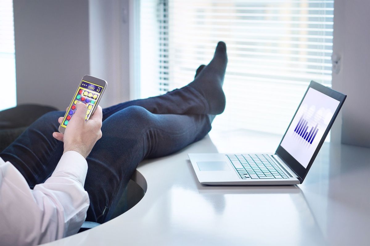 Lazy office worker playing mobile game
