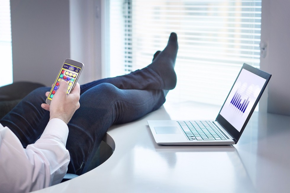 Lazy office worker playing mobile game