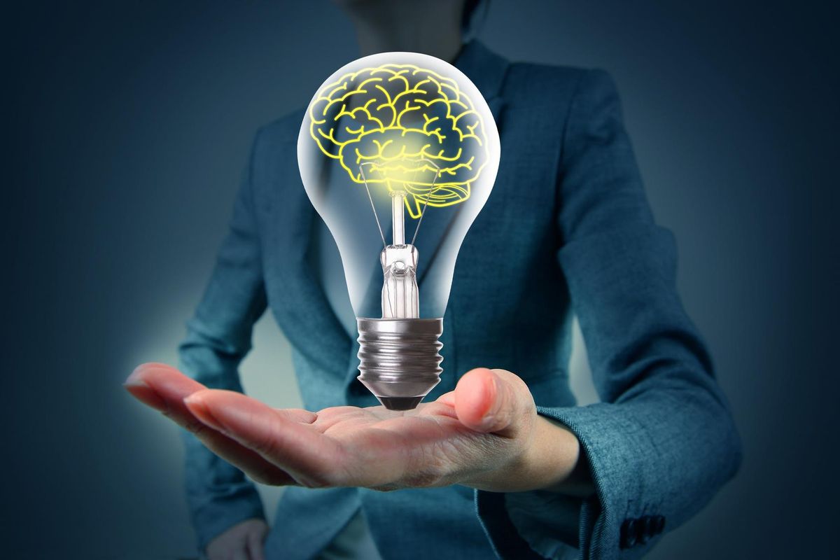 Light bulb in hand with brain
