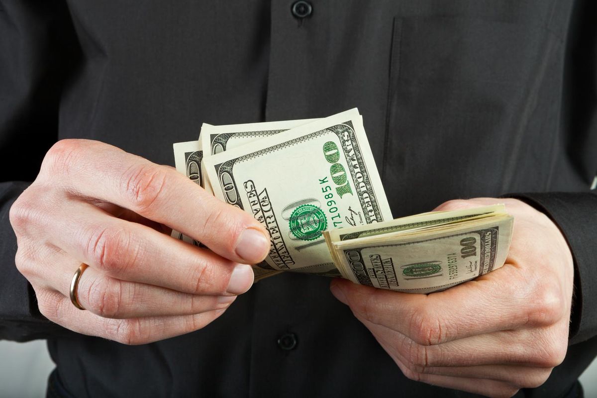 man counts money in hands dollar usa