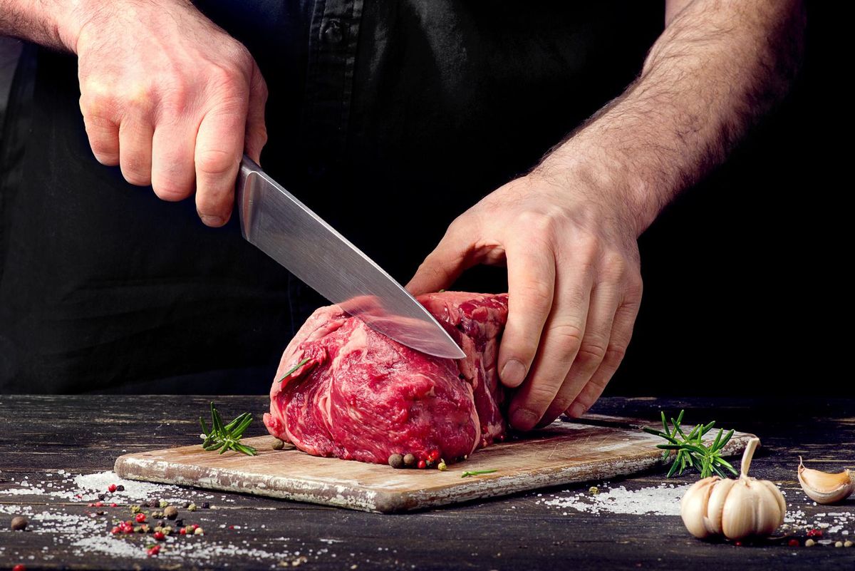 man cutting meat