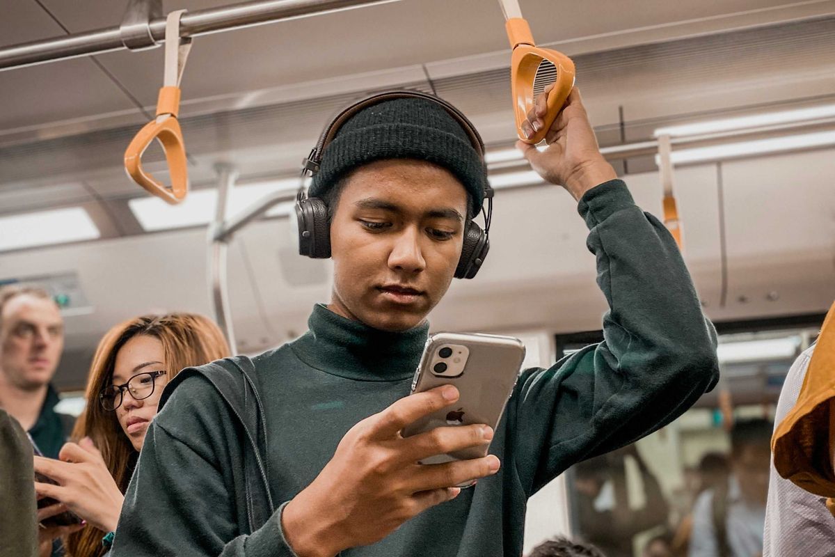 man in train holding smartphone