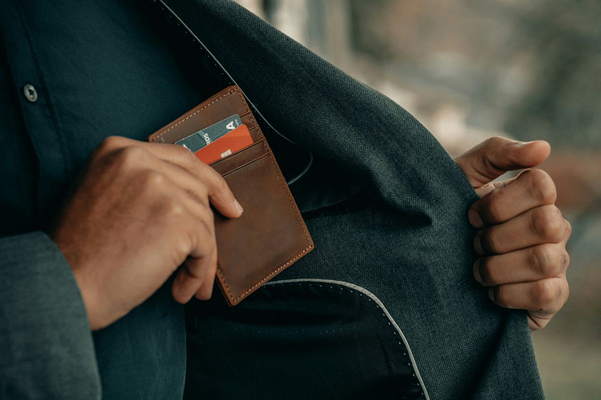 Man living paycheck to paycheck putting his wallet away