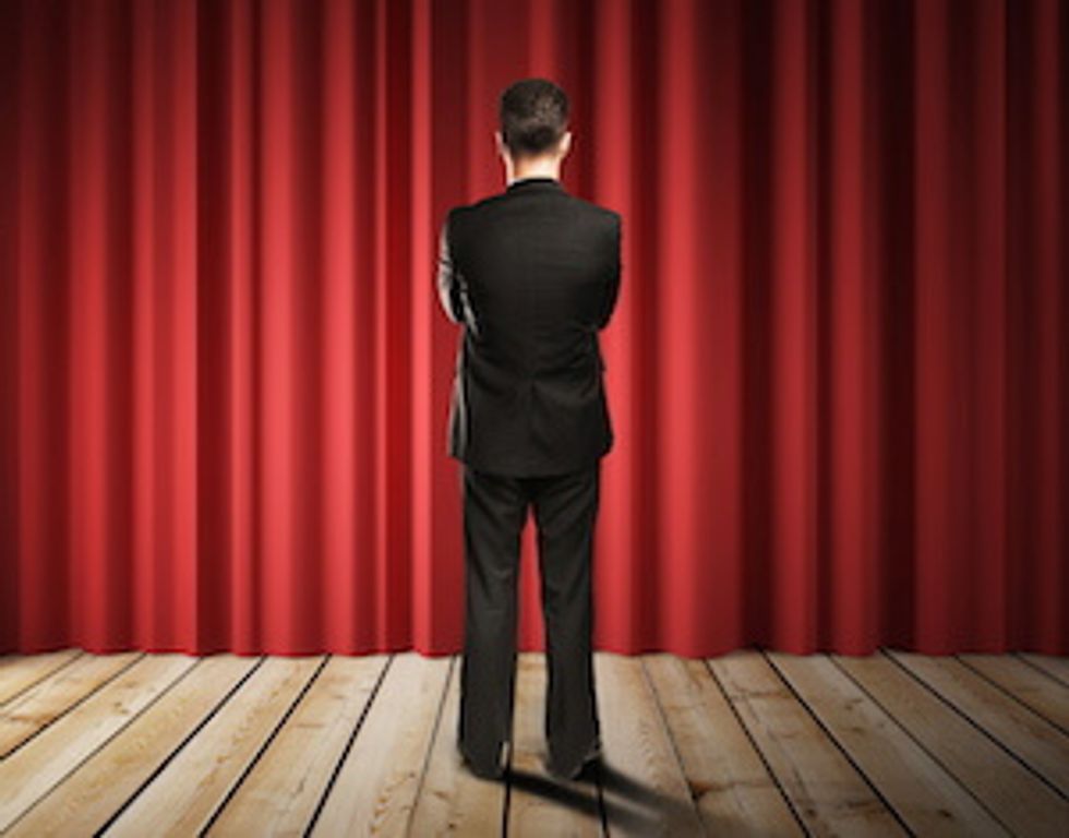 man on stage for sales presentation