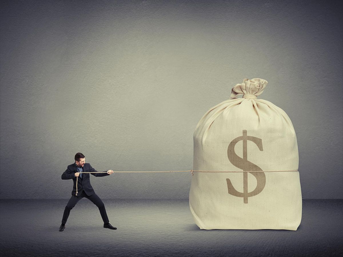 man pulling a big bag of money